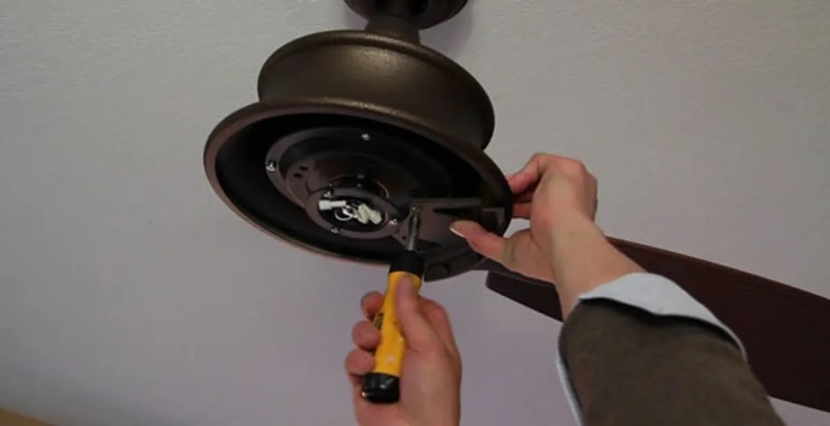 Electrician installing ceiling fan mounting bracket and fixture in Sacramento, CA