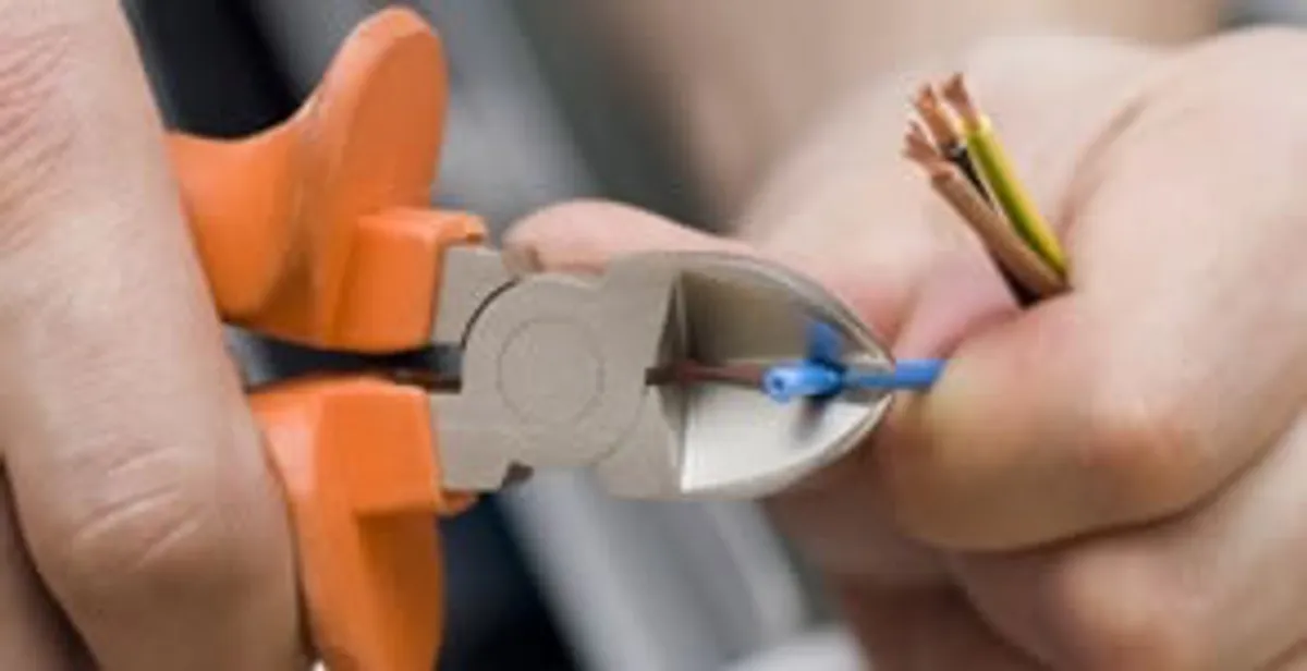 licensed electrician performing precise wire cutting and preparation during electrical service in Sacramento, CA